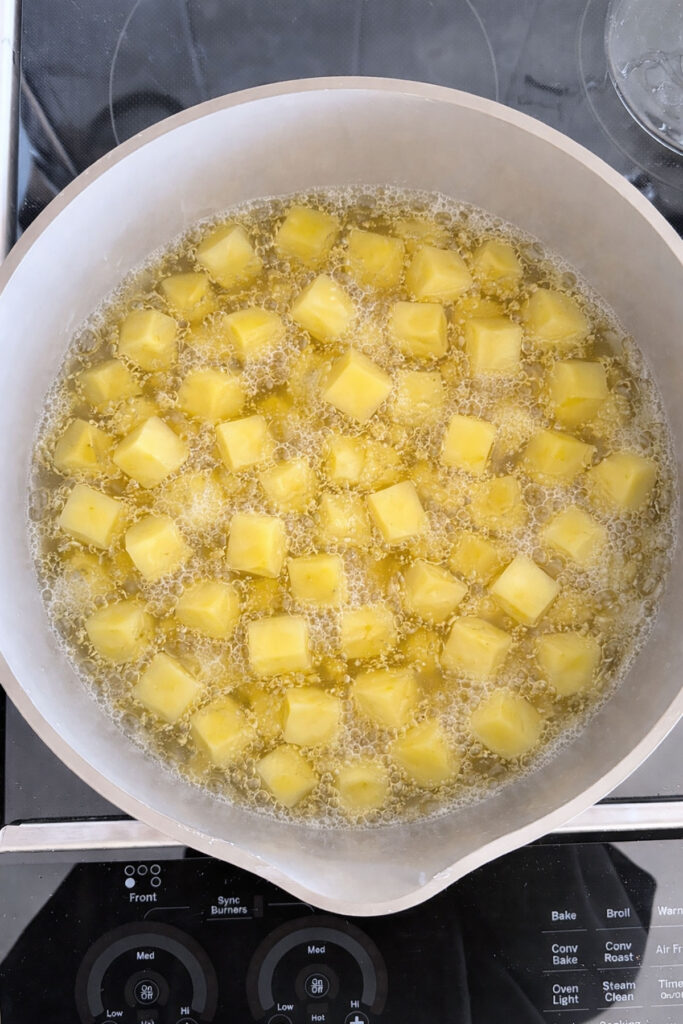 Potato cubes boiling in a pot.