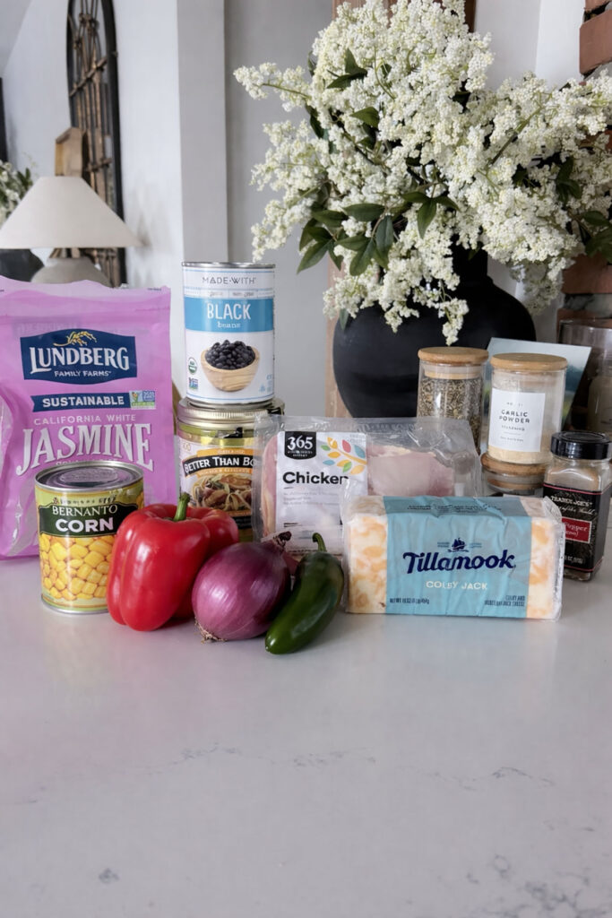 crockpot chicken burrito bowl ingredients on white counter with flowers and lamp in background