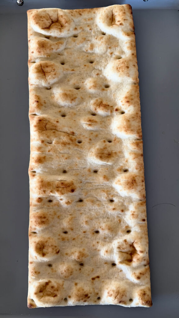 plain flatbread pizza crust on baking sheet