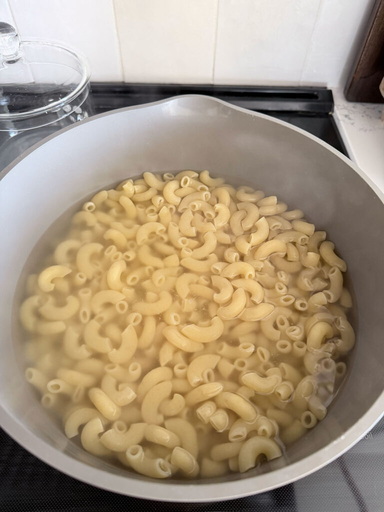 noodles cooking in water in pot on stove