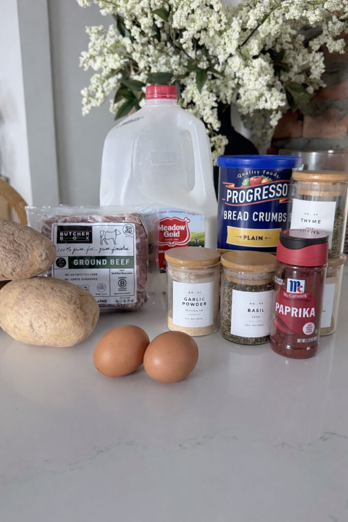 meatloaf casserole ingredients on white table with flowers in background