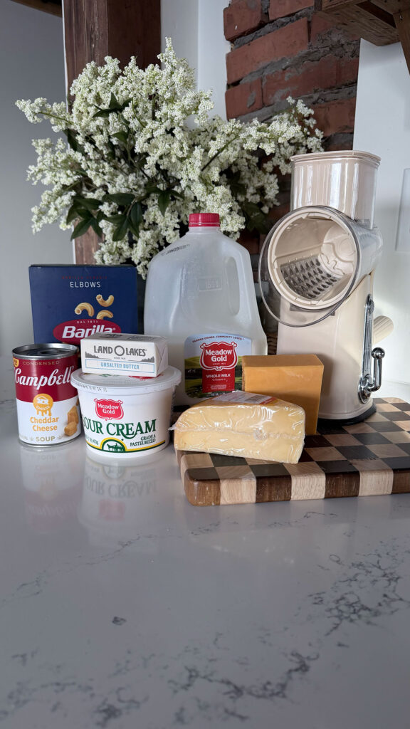 creamy mac and cheese ingredients on white/marble counter with flowers in background