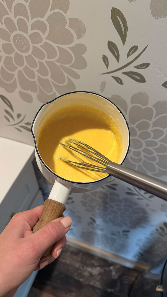 condensed cheddar soup cooked in pot with whisk in pot