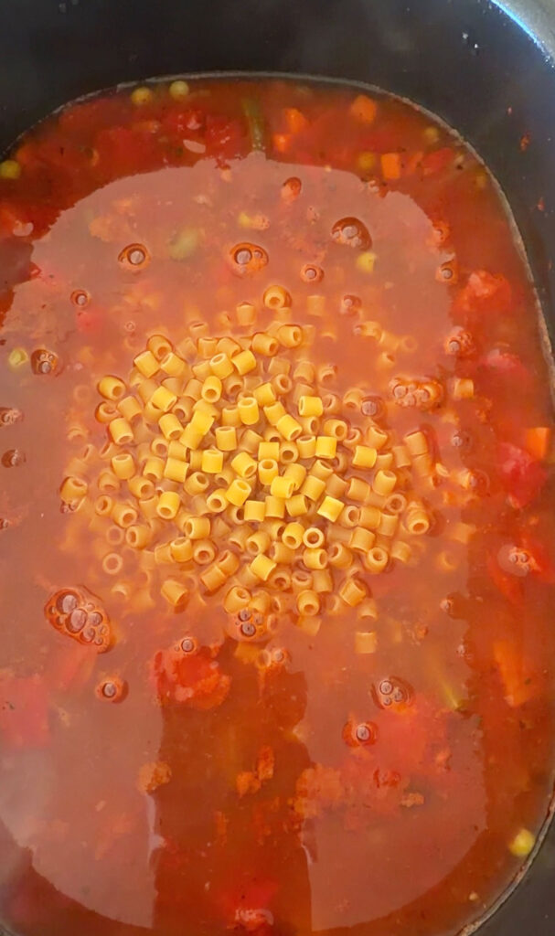 uncooked ditalini pasta added to crockpot minestrone