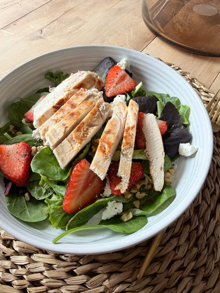 Strawberry Goat Cheese Salad in white bowl on placemat