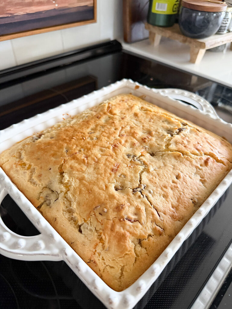 Baked pancake sausage casserole in a white baking dish on the stovetop.