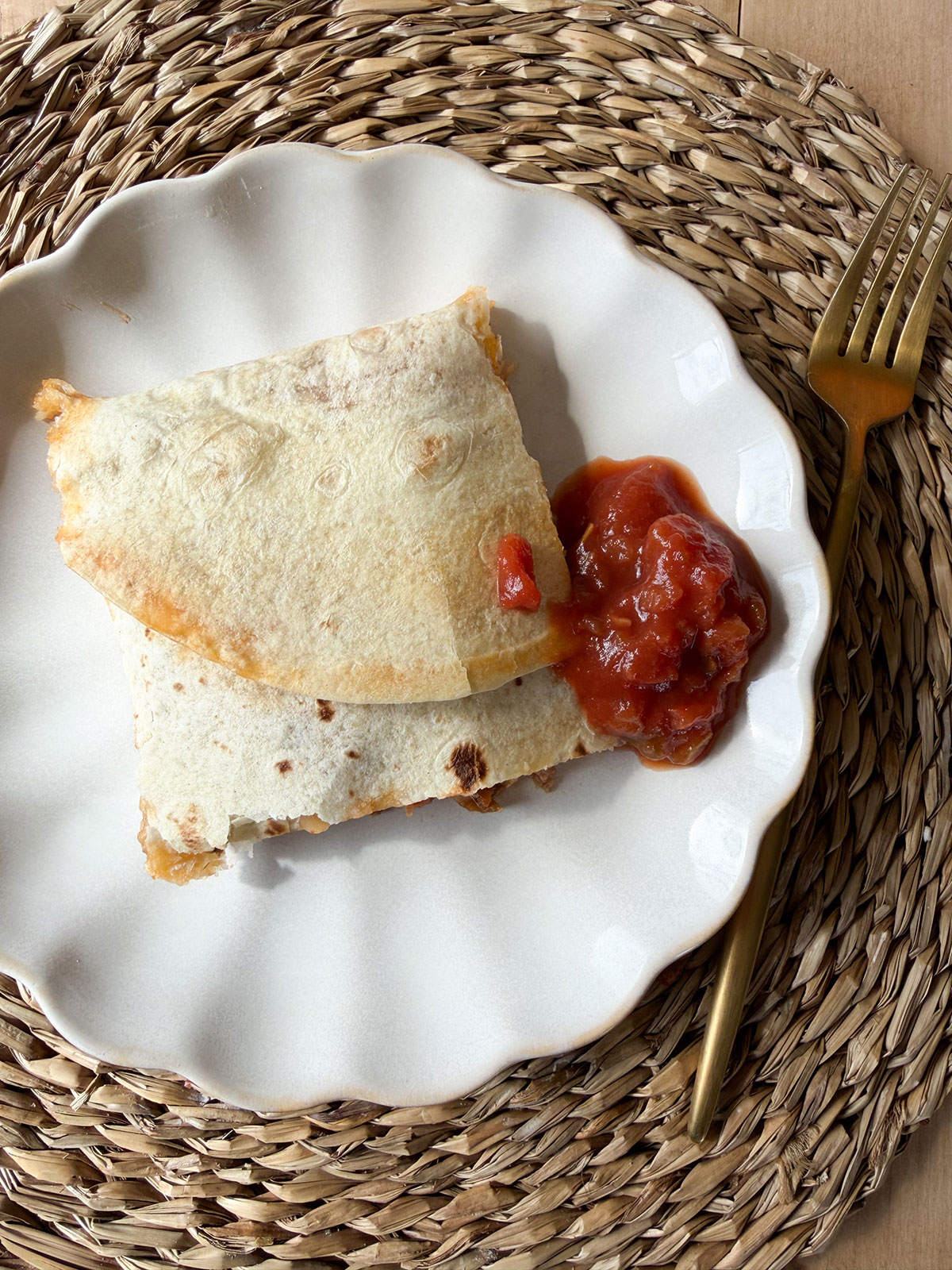 sheet pan quesadilla on white plate with salsa and gold fork next to plate