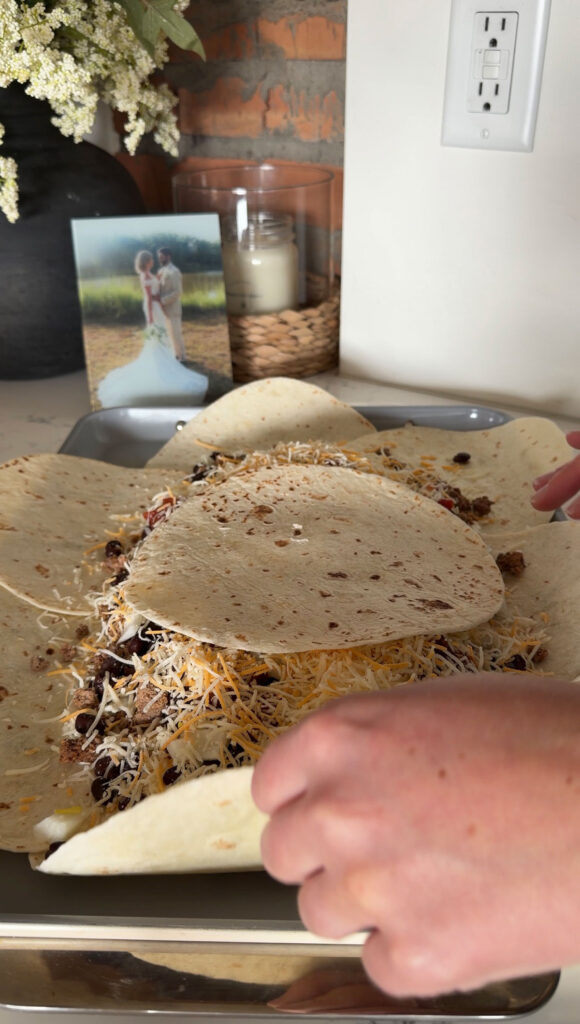 sheet pan quesadilla filled and being folded up