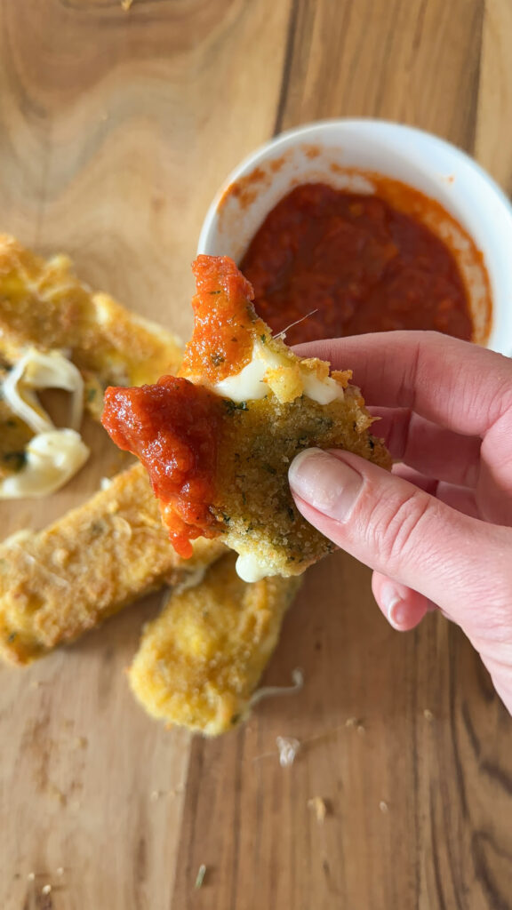 taking a bite of the mozzarella stick