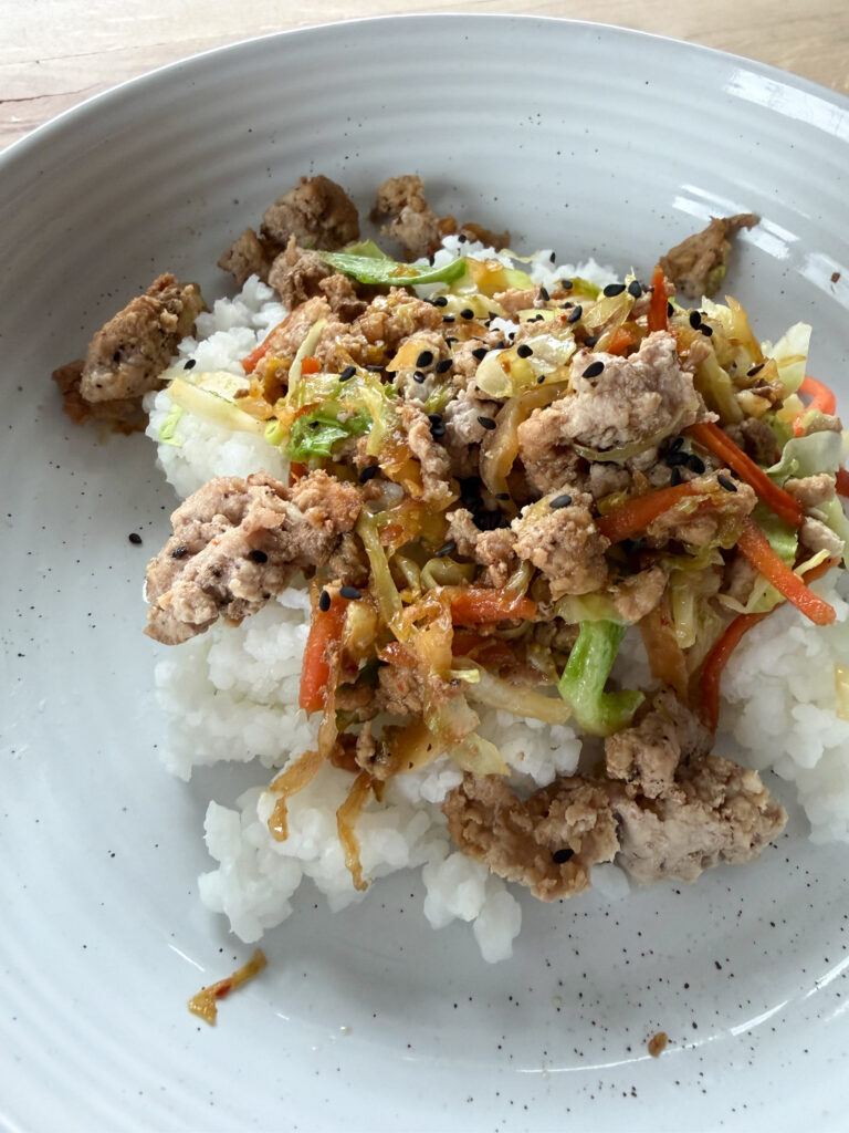 egg roll in a bowl over rice with black sesame seeds