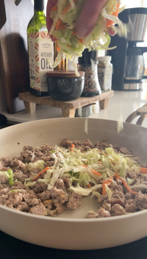 adding the coleslaw into the pan