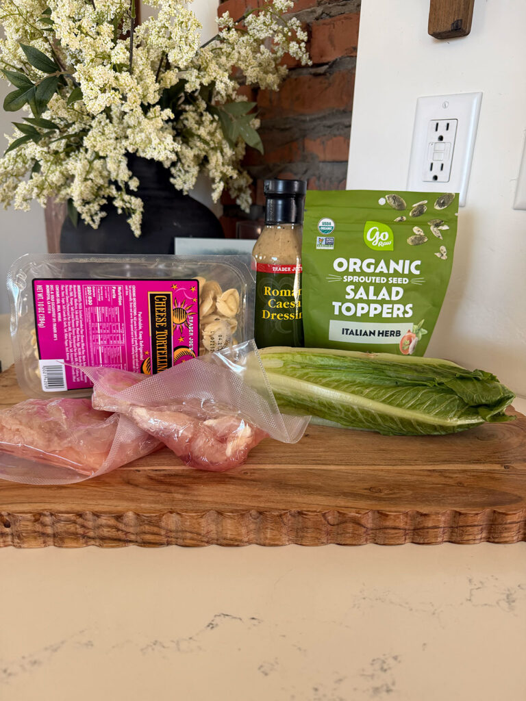 chicken tortellini caesar salad ingredients on cutting board on countertop