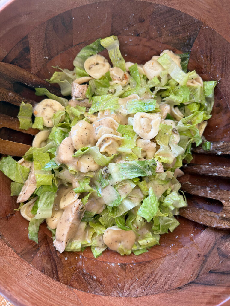 chicken tortellini caesar salad in wooden bowl