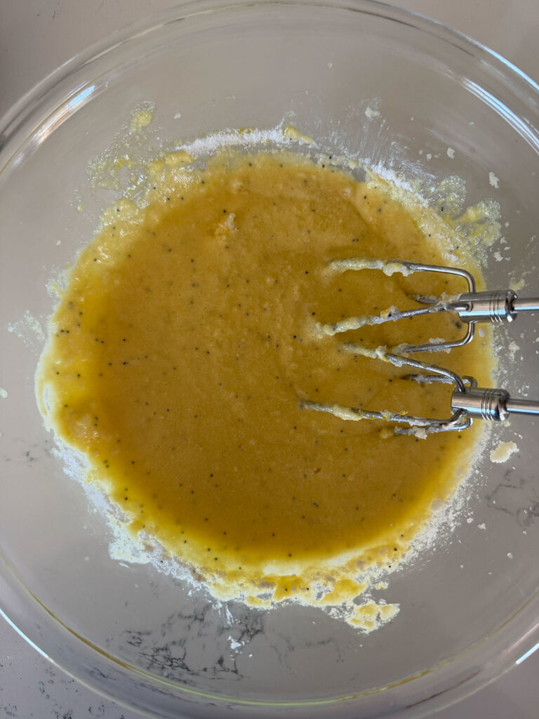 lemon poppyseed cupcake wet ingredients in glass bowl with mixer beaters