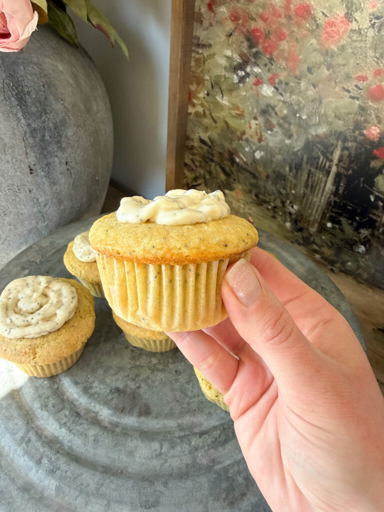 hand holding lemon poppyseed cupcake