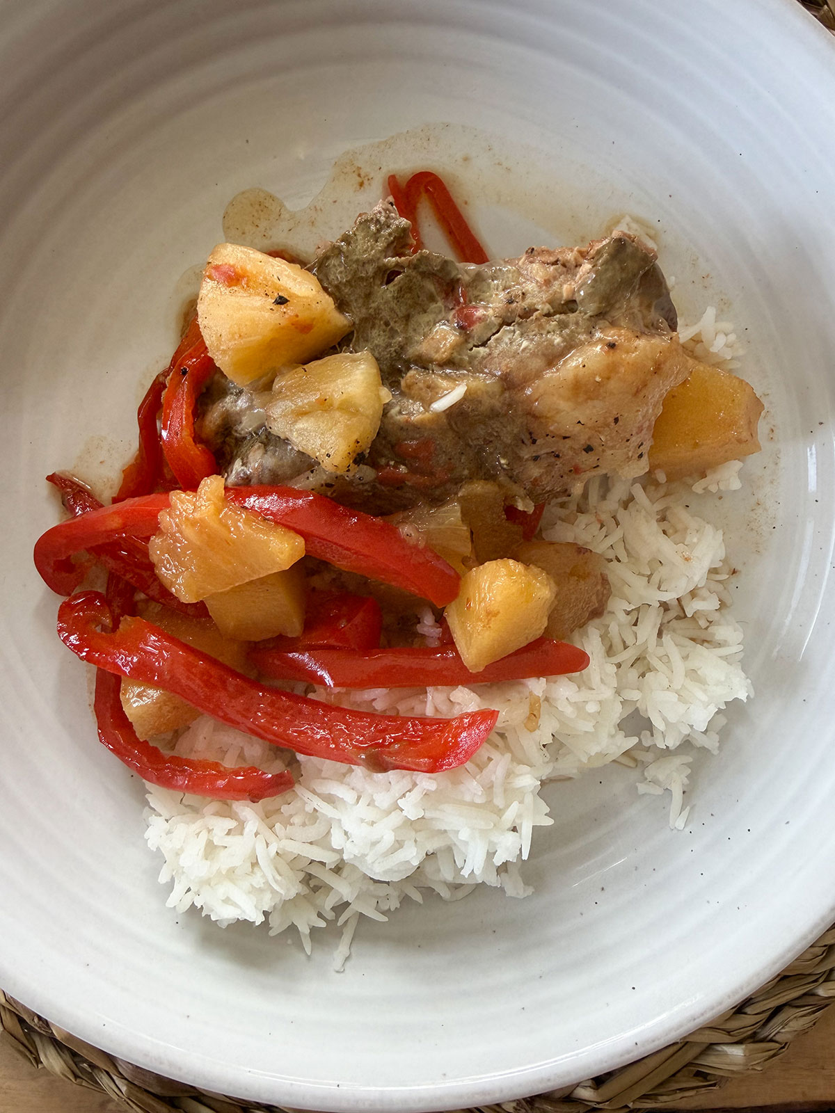 closer up shot of sweet and sour pork plated with white rice on white plate