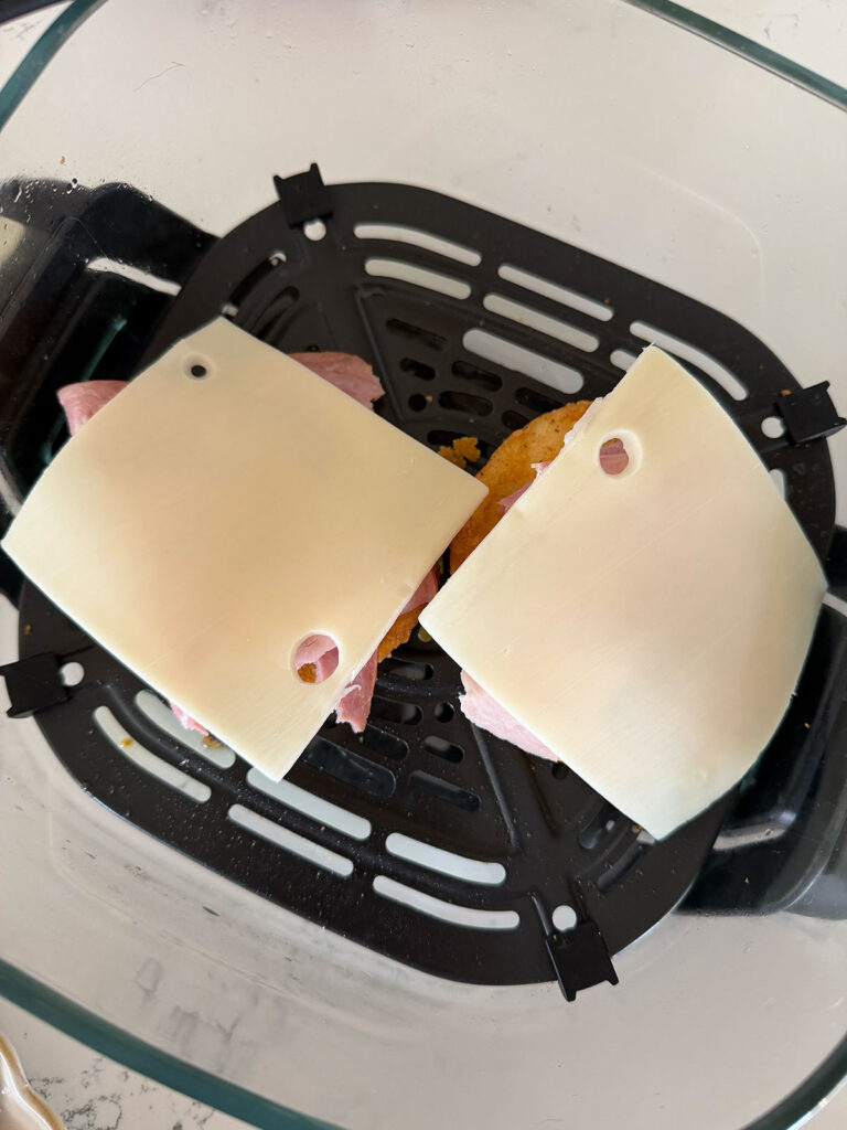 chicken topped with ham and swiss cheese in air fryer basket
