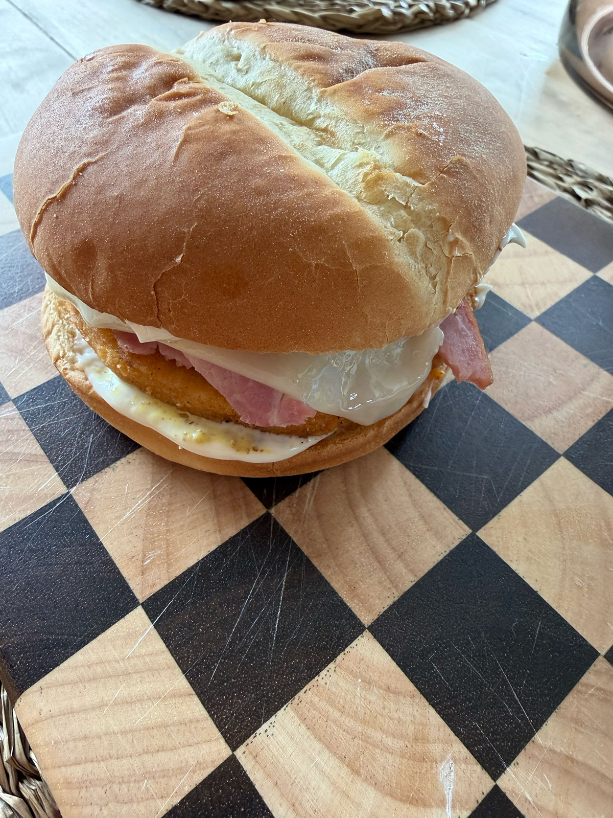 close up view of fully assembled, uncut, chicken cordon bleu sandwich