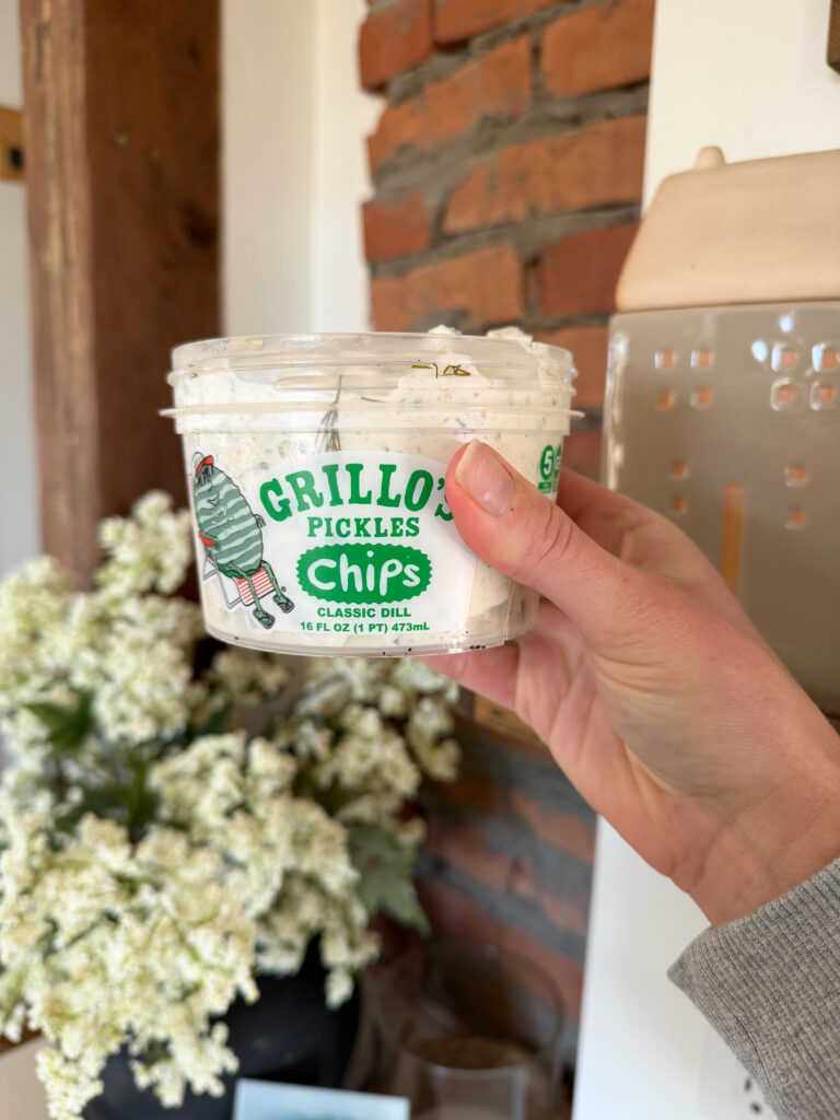 holding a grillos pickle container with the dip in it