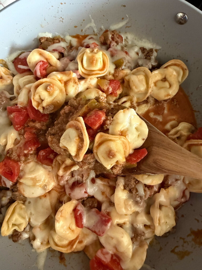 taco tortellini in pan with wooden spoonful coming up