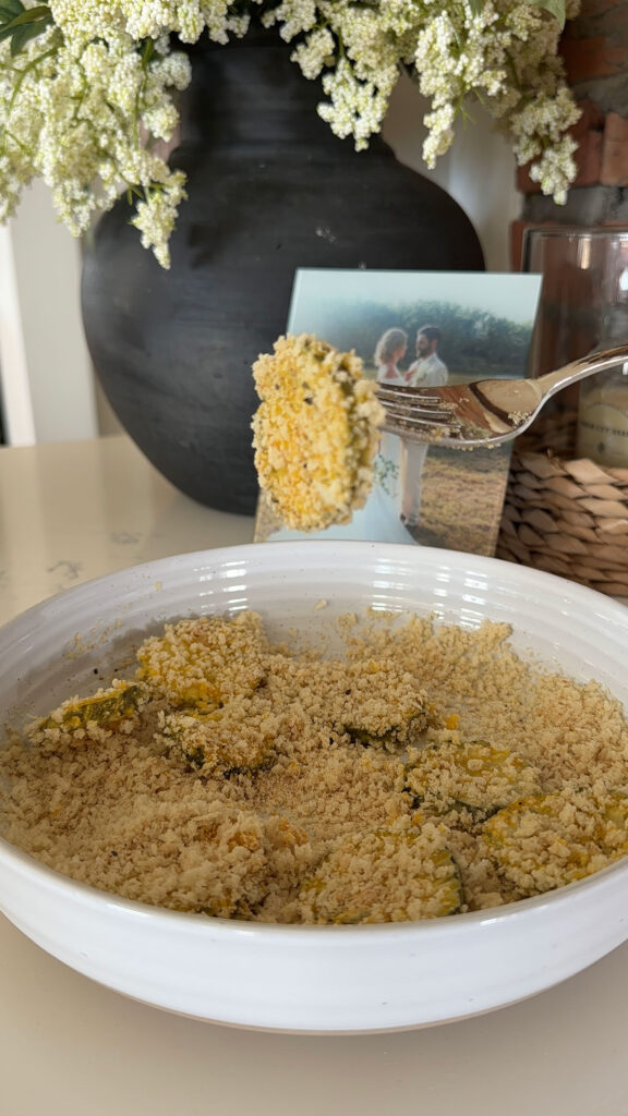 Dredging dill pickle slices in panko breadcrumbs.