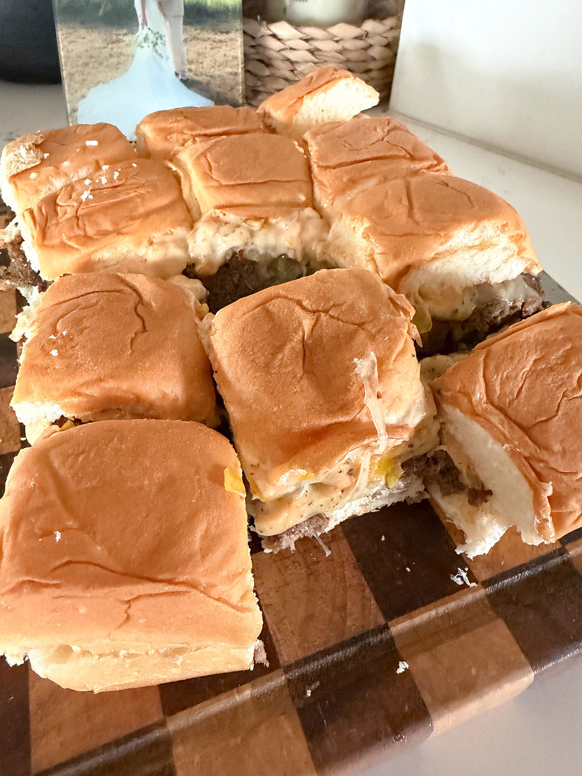 Sheet pan burgers cut up on checkered cutting board