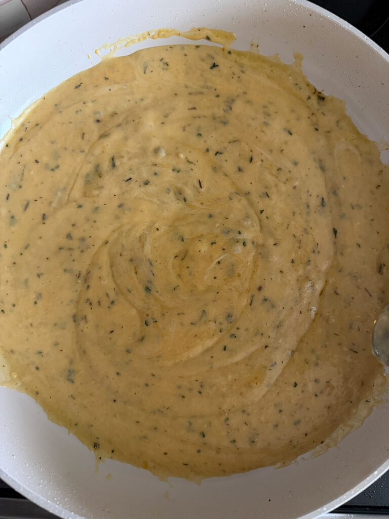 A sauce cooking in a white pan. 