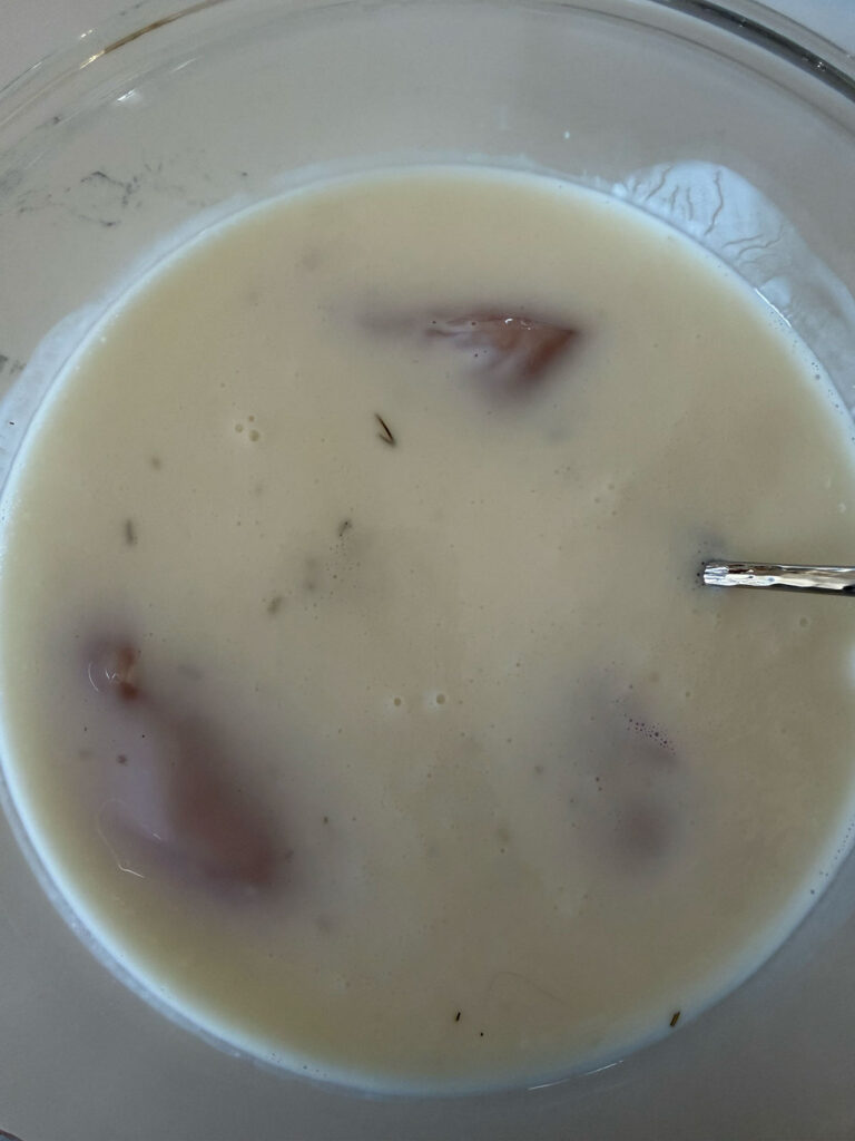 chicken in buttermilk pickle juice brine in glass bowl