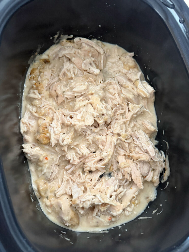 cooked, shredded chicken in creamy sauce in base of slow cooker