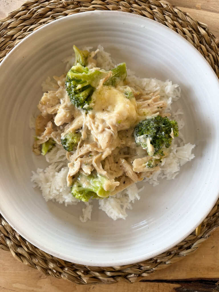 chicken divan over rice on white plate, on placemat