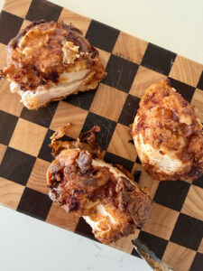 fried chicken pieces (3) on checkered cutting board