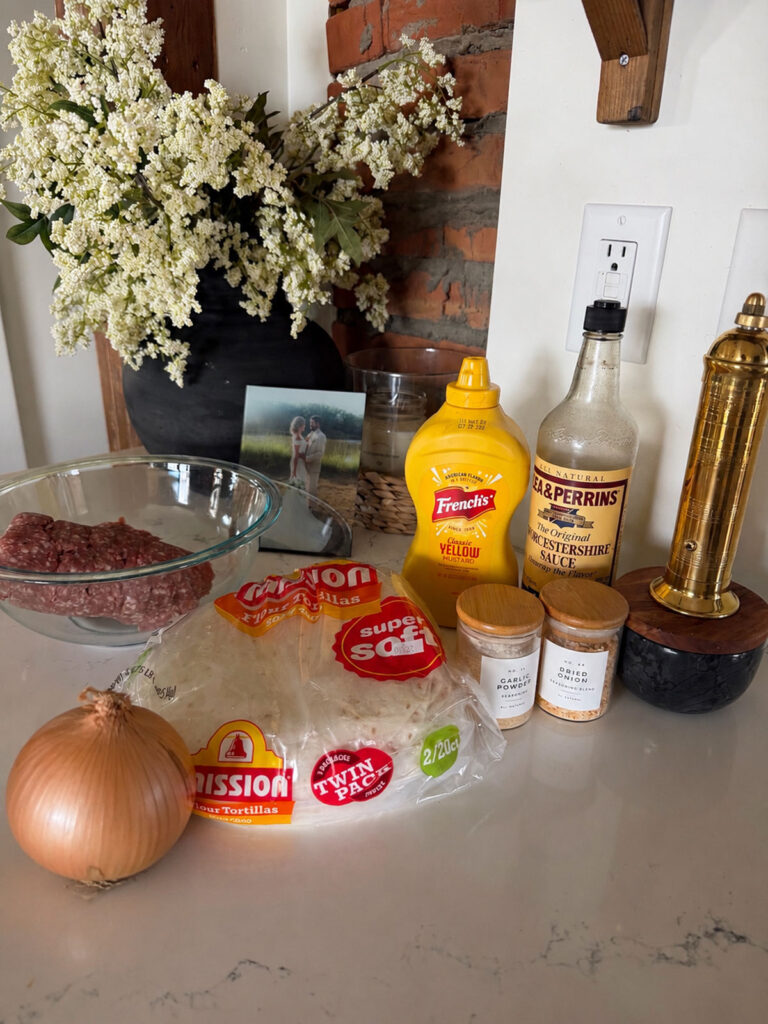 cheeseburger tacos ingredients on counter with flowers and photo in background