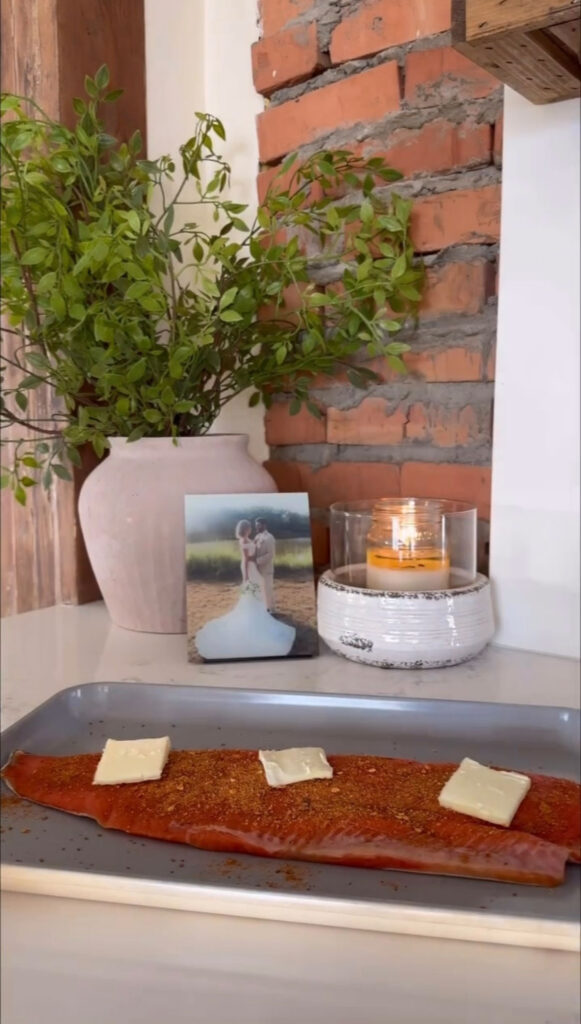 salmon on baking dish topped with pats of butter