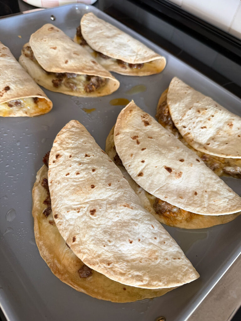 six cheeseburger tacos baked on a pan