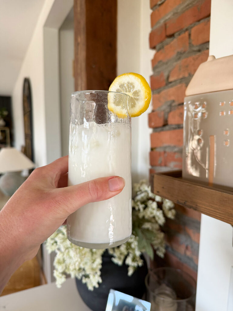 hand holding glass of creamy lemonade