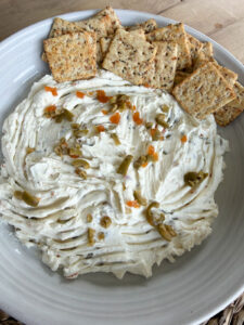 olive dip with crackers in white bowl