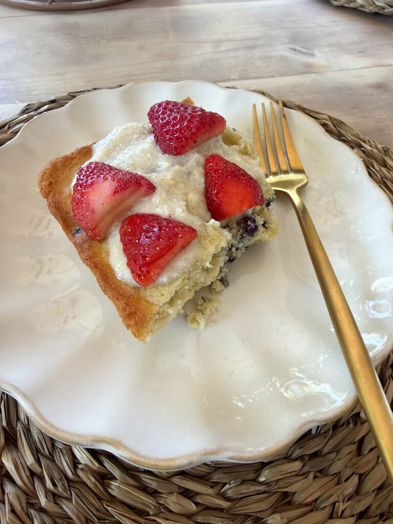 A white plate with a piece of flag cake and a gold fork next to it.