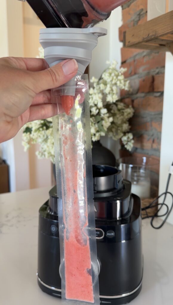 pouring strawberry mix into freeze pop
