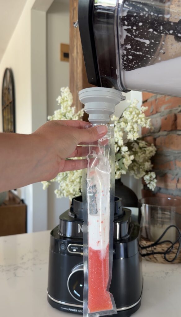 pouring white mixture into freeze pop