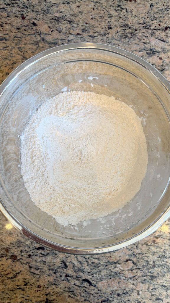 A metal bowl with flour for strawberry bundt cake.