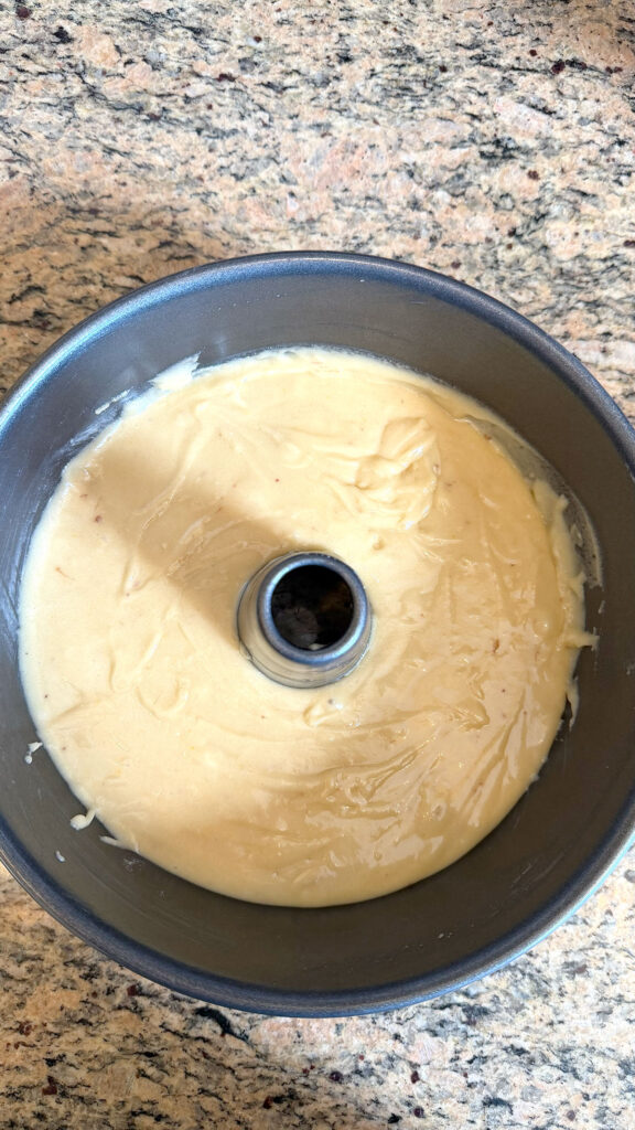 Cake batter in a bundt or tube pan for strawberry bundt cake.