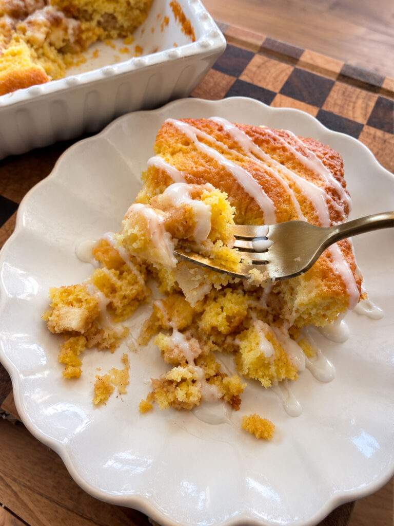 apple pie cake on white plate with forkful of cake