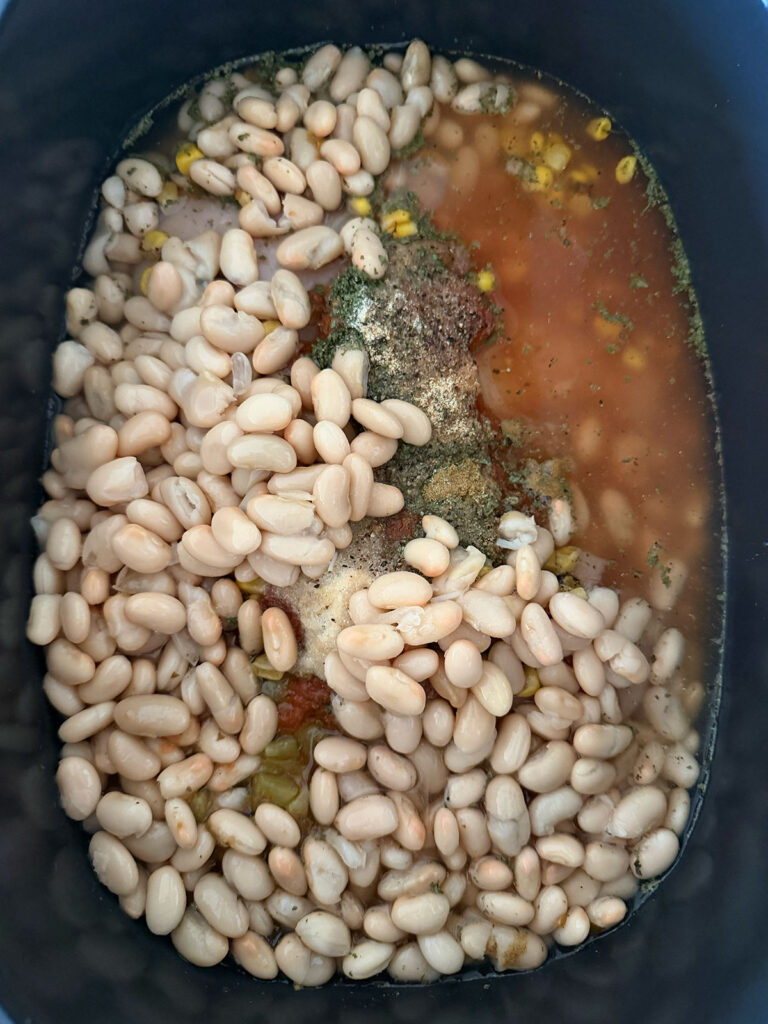 white chicken chili ingredients in base of crockpot