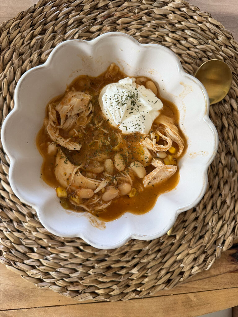 white chicken chili in white bowl on placemat