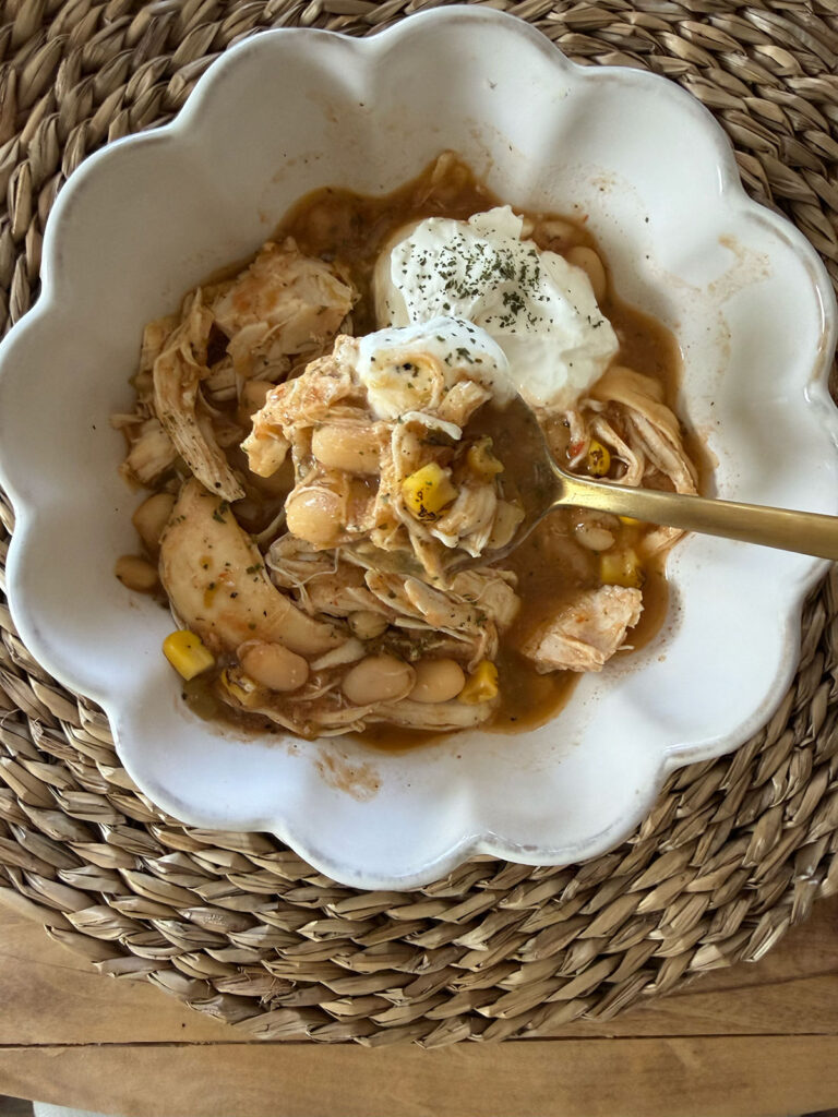 crockpot white chicken chili in bowl with gold spoon