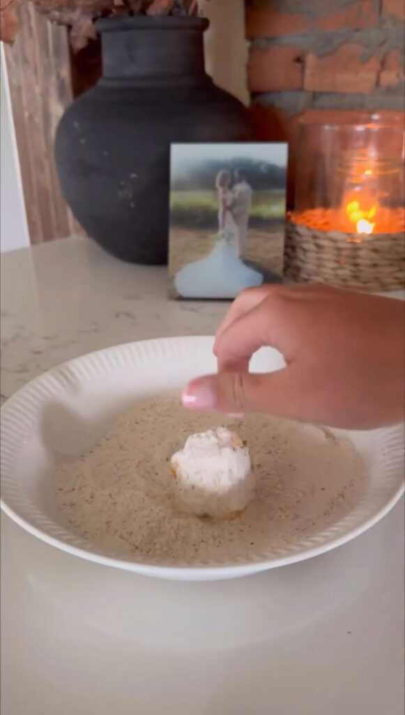 hand rolling fried pickle cheese ball in flour