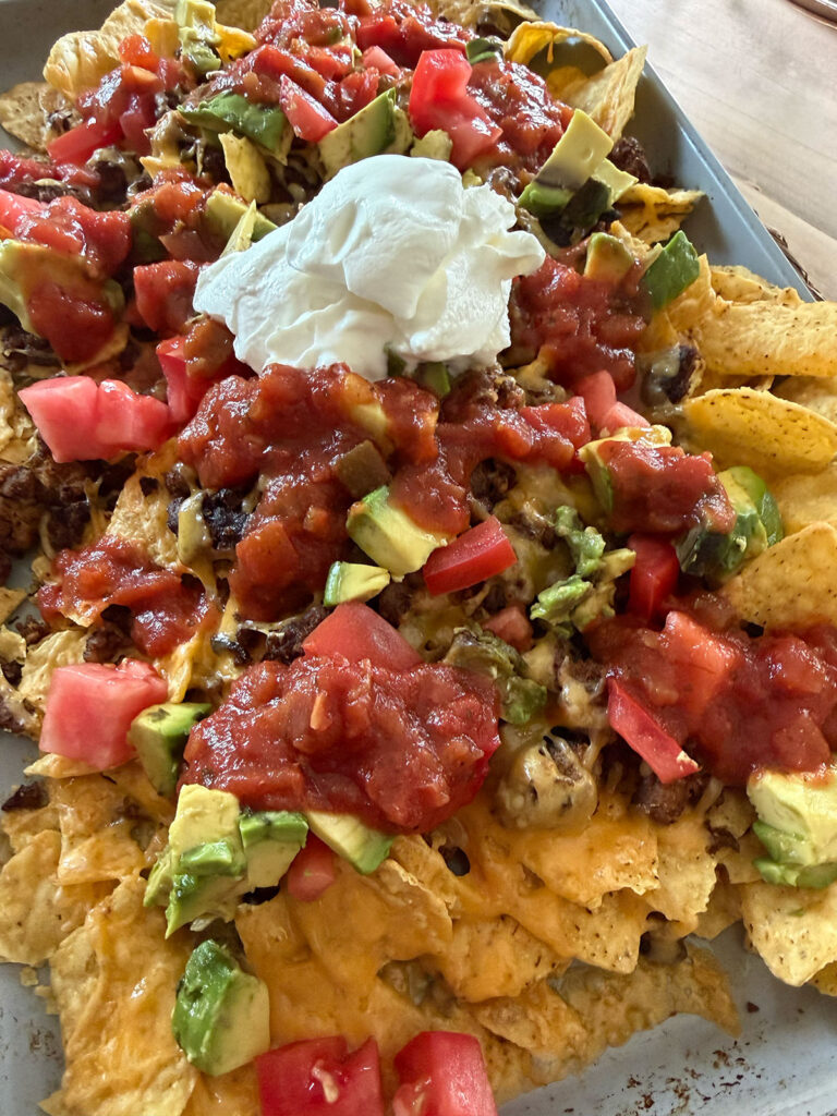 loaded sheet pan nachos with all the toppings on pan