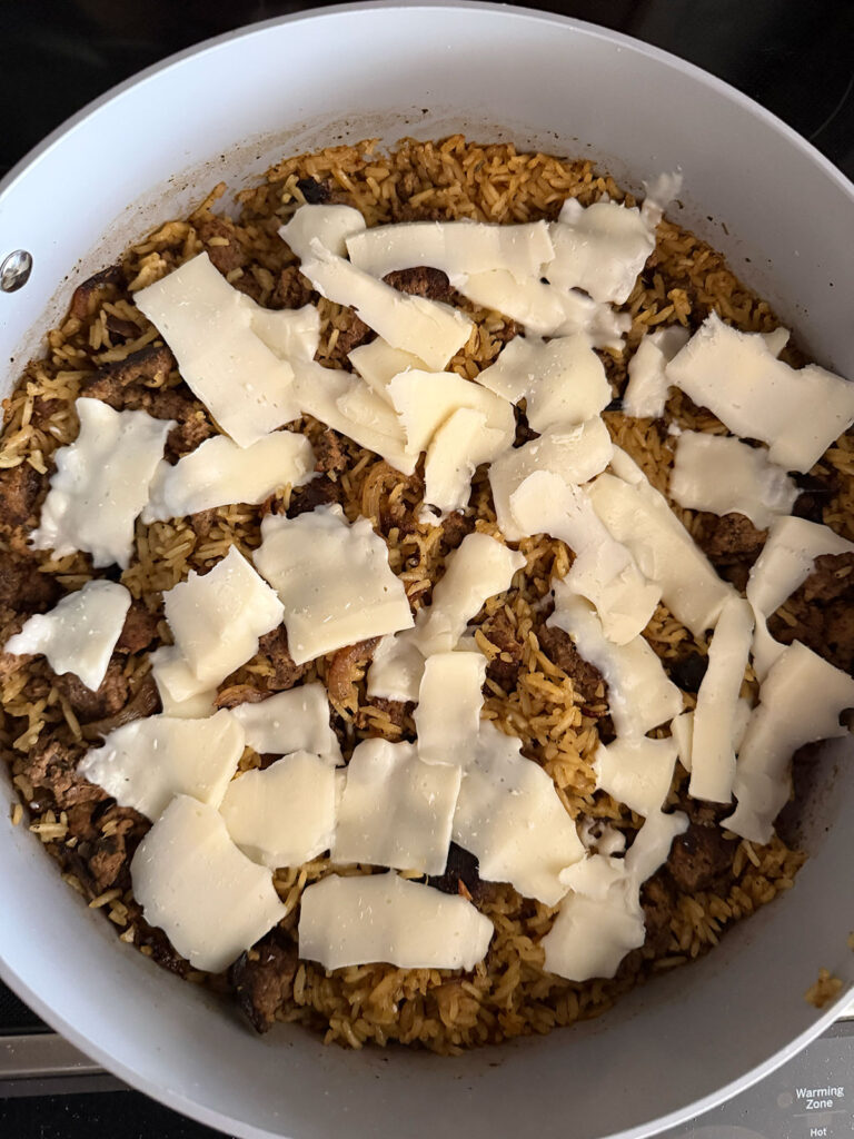 french onion ground beef casserole topped with cheese ready for onion