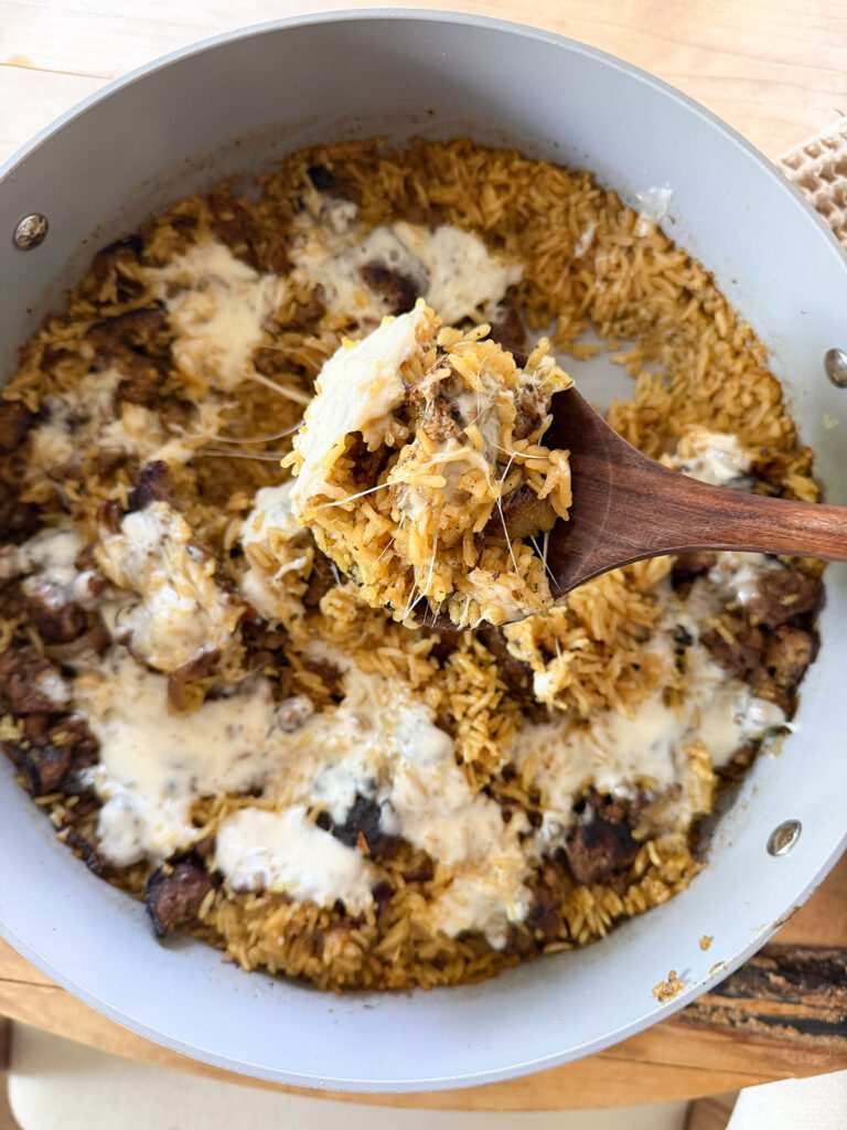 french onion ground beef casserole in pot with wooden spoon