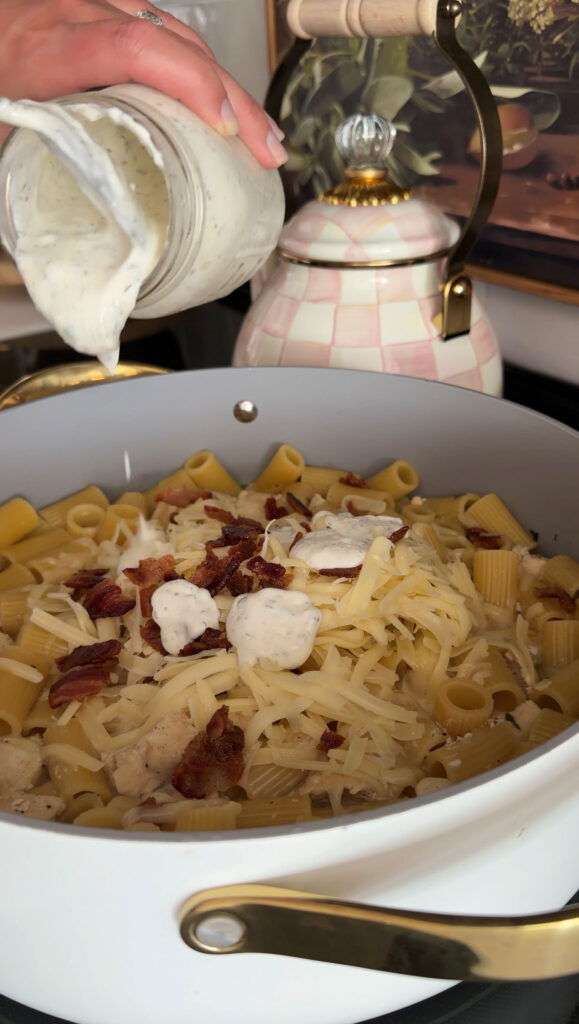 ranch dressing added to pan of pasta, bacon, and cheese